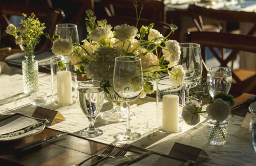 Beautiful table setting with White flowers, wine glasses and candles